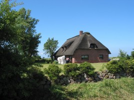 Hausansicht mit Liegewiese, Schaukel auch für Erwachsene geeignet und Sandkiste für die Kleinen / Ferienhaus "Ferienhaus Neukoog II" in Nordstrand