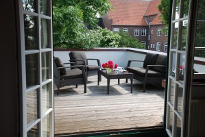 gemütliche Dachterrasse in Süd-West Lage. Genießen Sie die Ausblick auf Rosensträucher und Ruheinseln in der Altstadt von Husum. / Ferienwohnung "Altstadtidyll-Kapitänswohnung" in Husum / Nordsee