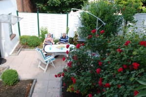 Der gemütliche Rosengarten mit Gartenmöbeln und Sonneschirm lädt zum Entspannen ein. / Ferienwohnung "Altstadtidyll -Gartenidyll" in Husum / Nordsee