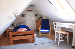 Schlafzimmer mit Einzelbett,
gemütlichem Sessel und Schreibtisch.
 / Ferienwohnung " Möwe" in Husum-Schobüll