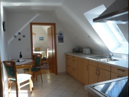 Küche mit Blick ins Wohnzimmer / Ferienwohnung "Rödemis" in Husum