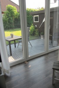 Wohnzimmer mit Zugang zur möblierten Terrasse und Garten / Ferienwohnung "Nordstern" in Hattstedt