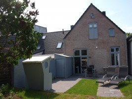 Sonnige Terrasse mit Gartenstühlen, Liegen und Strandkorb / Ferienhaus "Stadthuus 51" in Husum