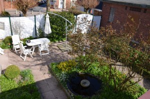 der Blick in den Rosengarten mit Springbrunnen / Ferienwohnung "Altstadtidyll-Kapitänswohnung" in Husum / Nordsee