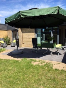 Terrasse mit Schwenkschirm und Gartenstühlen lädt zum Grillen ein! / Ferienhaus "Bungalow Kleine Auszeit" in Husum