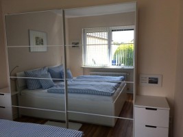 Schlafzimmer mit großem Spiegelkleiderschrank / Ferienhaus "Bungalow Kleine Auszeit" in Husum