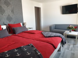 Das große Schlafzimmer mit zusätzlichem Sofa und Flachbildfernseher / Ferienwohnung "Kleiner Onkel" in Hattstedtermarsch