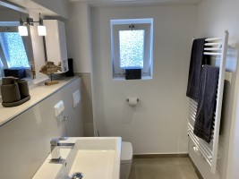 Sanitärbereich mit Toilette und Handtuchwärmer. / Ferienhaus "Ferienhaus Neukoog II" in Nordstrand