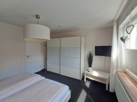 Schlafzimmer mit Tresor und zweitem Fernseher / Ferienwohnung "Urlaub-schön und apart" in Husum